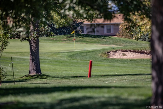 view of home's community with golf course view and a yard