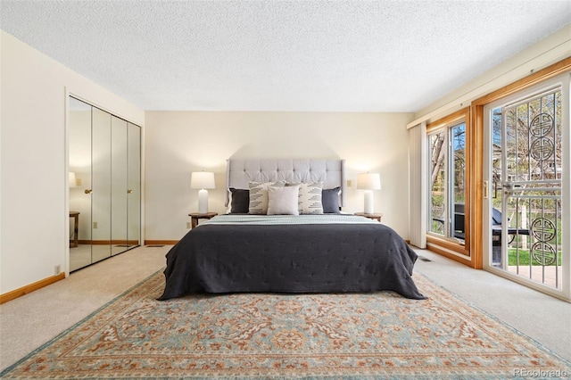 carpeted bedroom with baseboards, a textured ceiling, and access to exterior