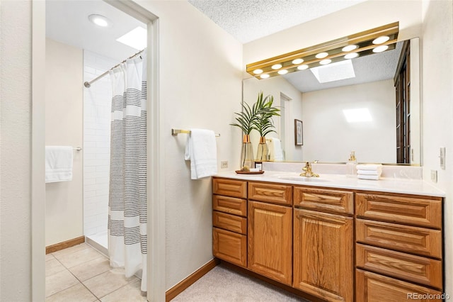 bathroom with a skylight, a shower with curtain, baseboards, and vanity