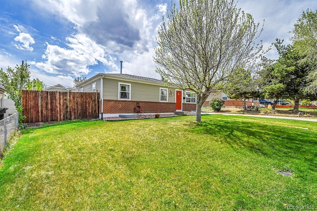 view of front of property with fence, a front lawn, and brick siding