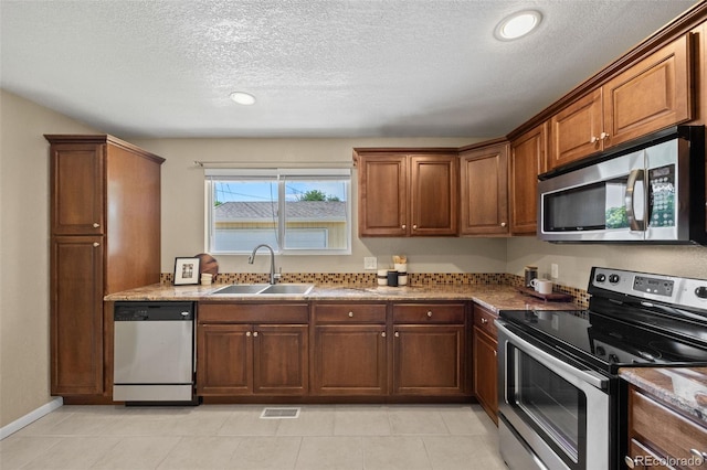 2380 W Baltic Pl, Englewood, CO 80110 - kitchen featuring appliances with stainless steel finishes, a textured ceiling, light tile patterned floors, and recessed lighting
