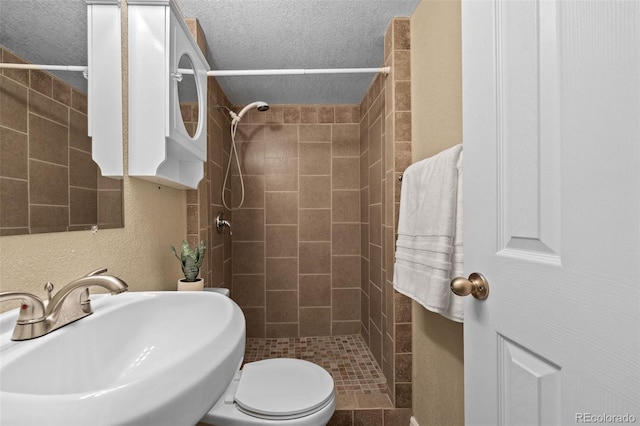 2380 W Baltic Pl, Englewood, CO 80110 - bathroom featuring tiled shower, a textured ceiling, and a textured wall