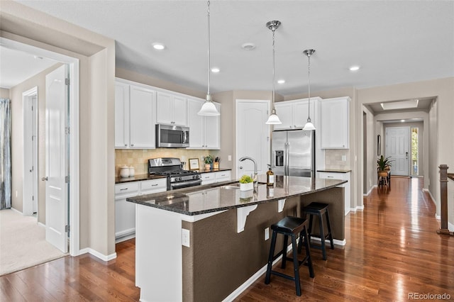 827 Sundance Ln, Erie, CO 80516 - kitchen with backsplash, a sink, dark wood-type flooring, and appliances with stainless steel finishes