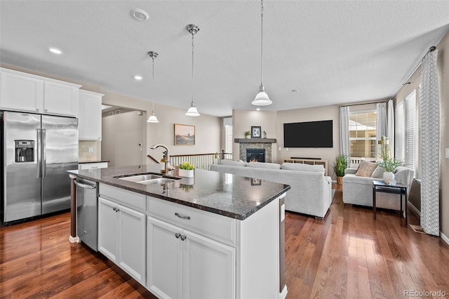 827 Sundance Ln, Erie, CO 80516 - kitchen featuring stainless steel appliances, a sink, dark stone counters, and dark wood finished floors