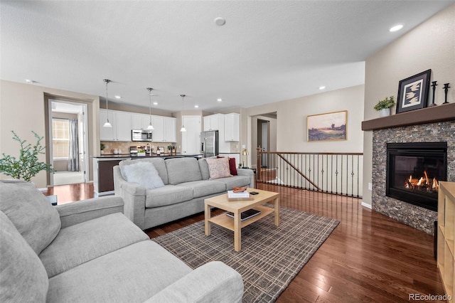 827 Sundance Ln, Erie, CO 80516 - living room with a fireplace, baseboards, a textured ceiling, and dark wood-style floors