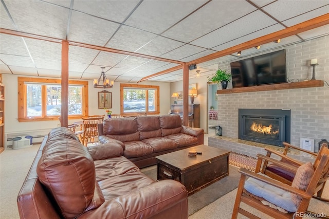 living room with carpet, a brick fireplace, and a paneled ceiling