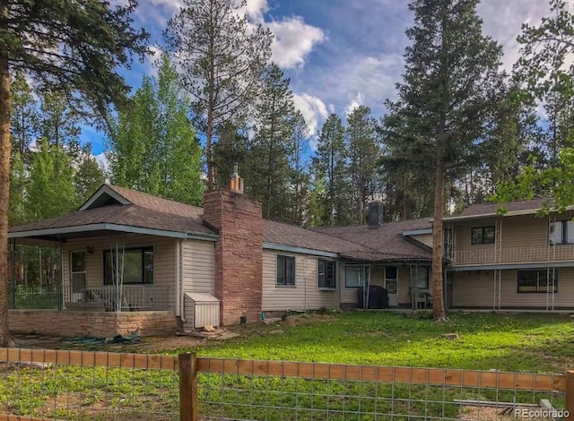 view of front of house featuring a chimney and a front yard