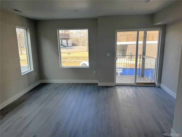 unfurnished room with visible vents, baseboards, and wood finished floors