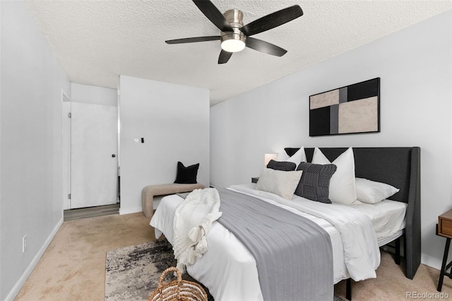 carpeted bedroom with a ceiling fan, a textured ceiling, and baseboards