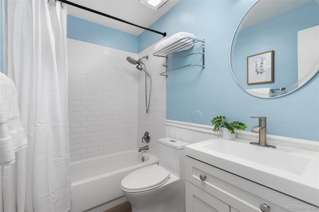 bathroom featuring toilet, shower / bath combo with shower curtain, and vanity