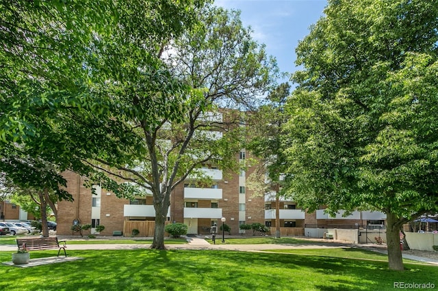 view of property's community with fence and a lawn