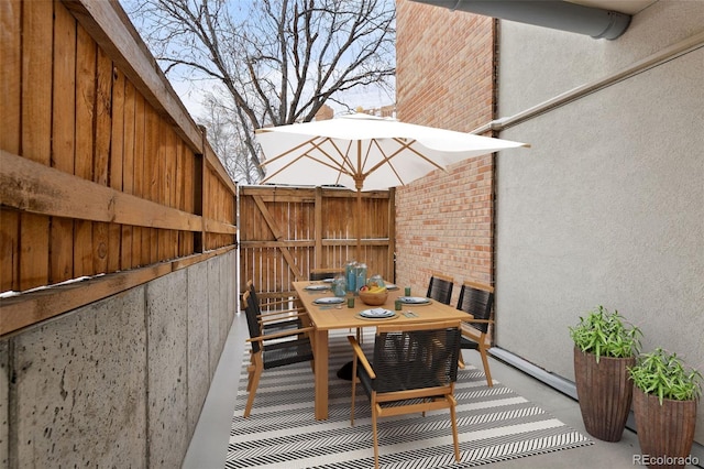 view of patio featuring outdoor dining area and fence