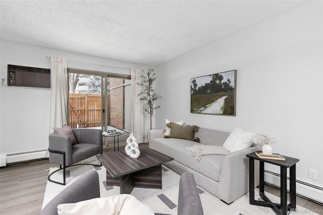 living room featuring an AC wall unit, a textured ceiling, baseboard heating, and wood finished floors