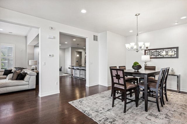 dining space with a chandelier and dark wood-type flooring