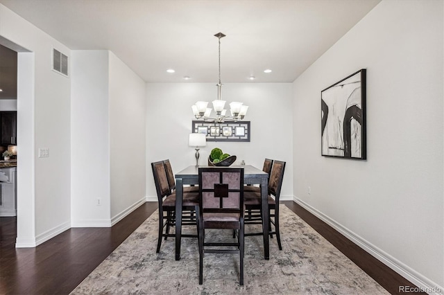 dining area featuring dark hardwood / wood-style flooring and a chandelier