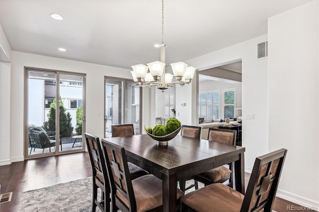 dining area with dark hardwood / wood-style flooring and a chandelier