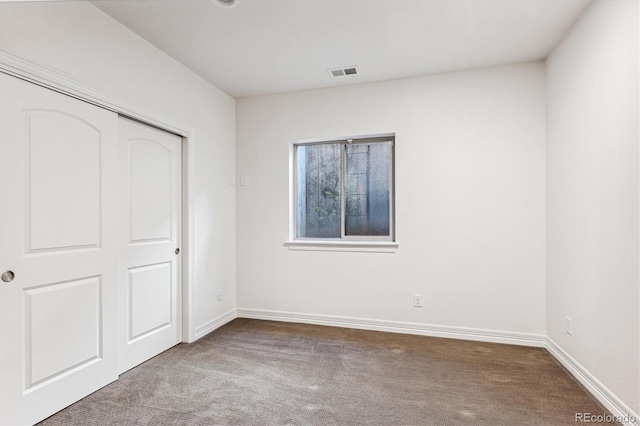 unfurnished bedroom with light colored carpet and a closet