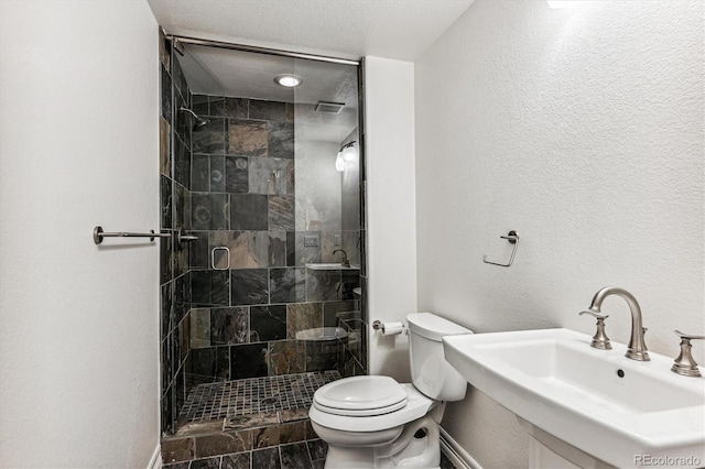 bathroom featuring toilet, a shower with door, and sink