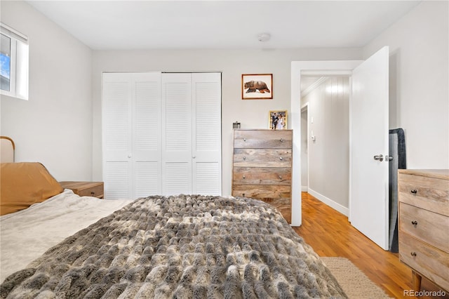 bedroom with light hardwood / wood-style flooring and a closet