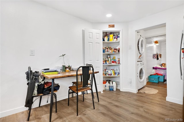 office space featuring stacked washer / drying machine and light hardwood / wood-style flooring