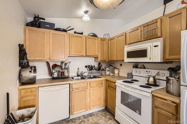 kitchen with white appliances, light brown cabinetry, and sink