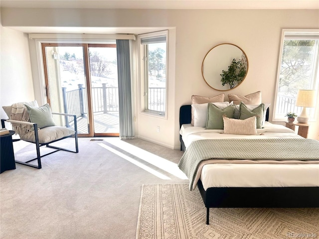 bedroom featuring access to exterior, light carpet, and multiple windows