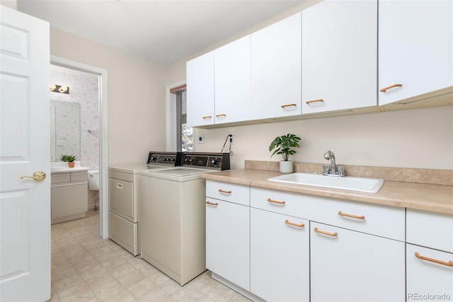 laundry area featuring cabinets, sink, and washer and dryer