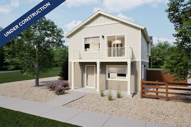 view of front facade featuring a balcony, fence, and board and batten siding