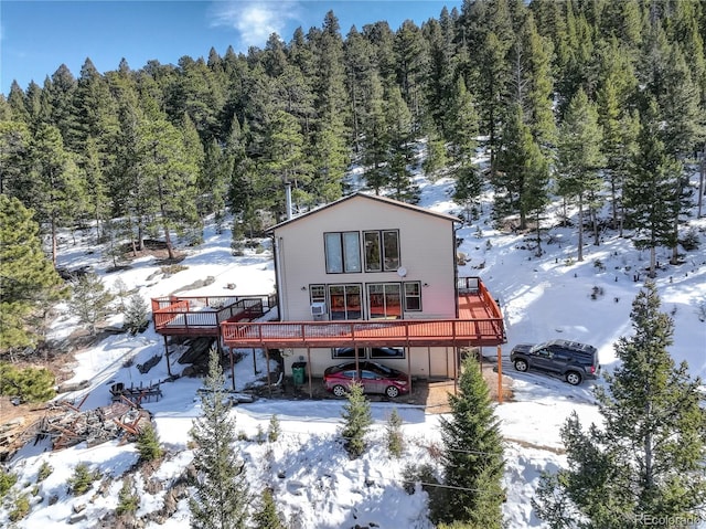 snow covered property featuring a wooden deck