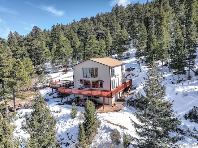 snow covered rear of property featuring a deck