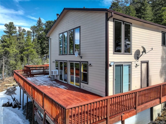 snow covered rear of property featuring a wooden deck