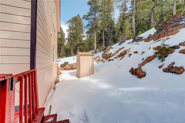 yard layered in snow with a shed