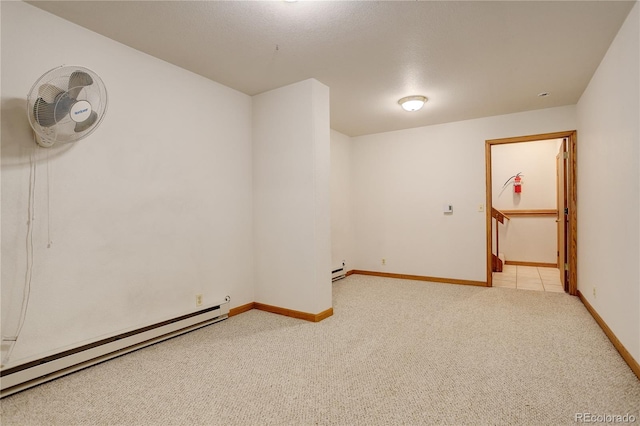 empty room with light carpet and a baseboard heating unit