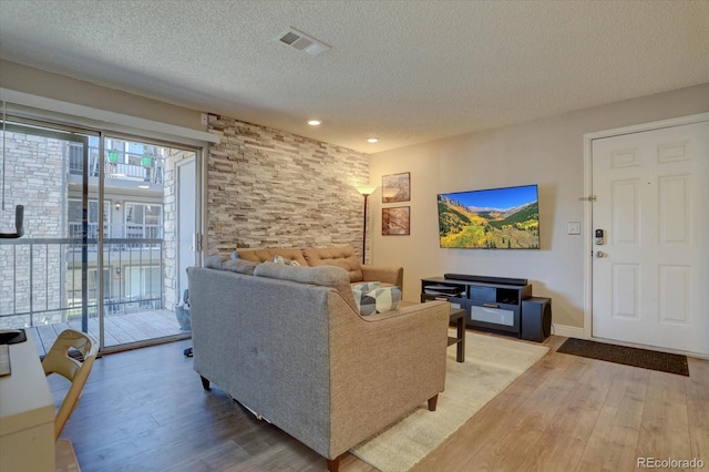 living room with wood-type flooring and a textured ceiling