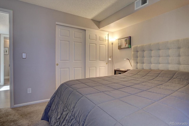 bedroom featuring carpet, a textured ceiling, and a closet