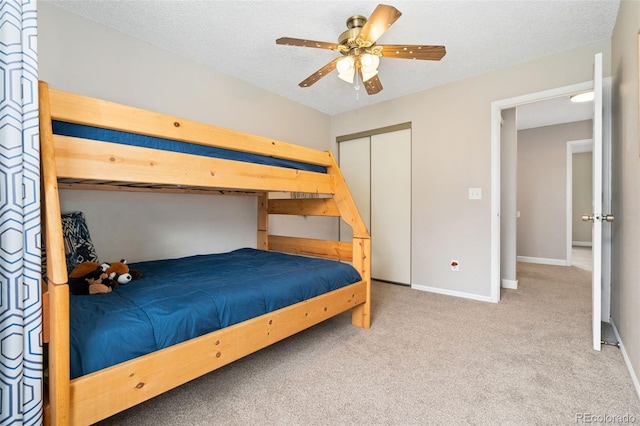 bedroom featuring baseboards, carpet flooring, a textured ceiling, and a closet