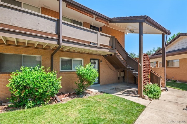 12820 Willow Ln Unit 9, Golden, CO 80401 - back of property with brick siding, a lawn, stairs, and a patio