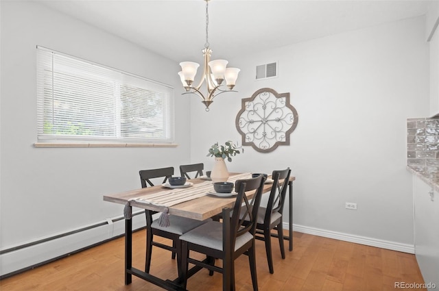 12820 Willow Ln Unit 9, Golden, CO 80401 - dining room featuring a baseboard heating unit, a chandelier, and light wood-style floors