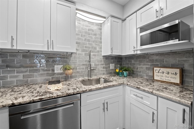 12820 Willow Ln Unit 9, Golden, CO 80401 - kitchen featuring stainless steel dishwasher, white cabinets, and decorative backsplash