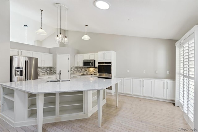 kitchen featuring a large island with sink, light stone countertops, sink, white cabinetry, and stainless steel appliances