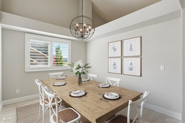 dining room with light hardwood / wood-style flooring, a notable chandelier, and vaulted ceiling