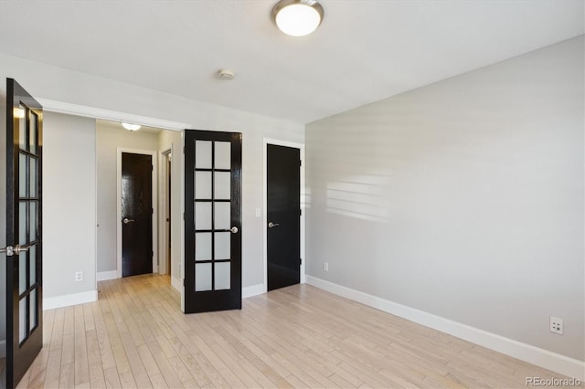 empty room featuring french doors and light hardwood / wood-style floors