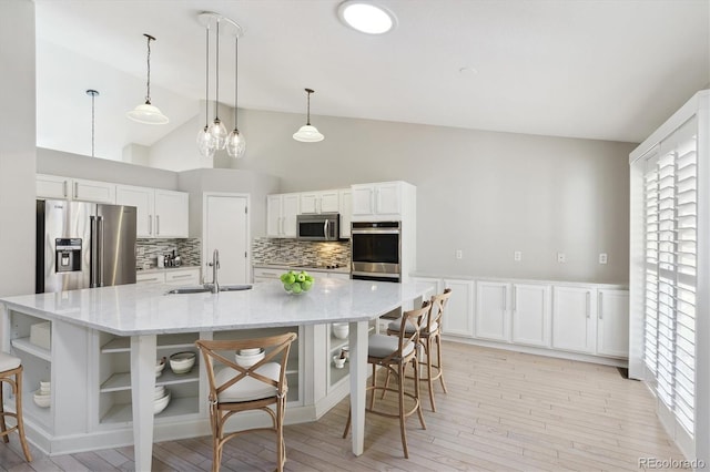 kitchen with a spacious island, stainless steel appliances, sink, and white cabinets