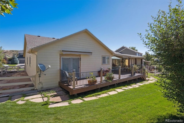 rear view of house with a yard and a deck