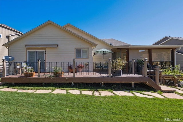 back of house featuring a deck and a lawn