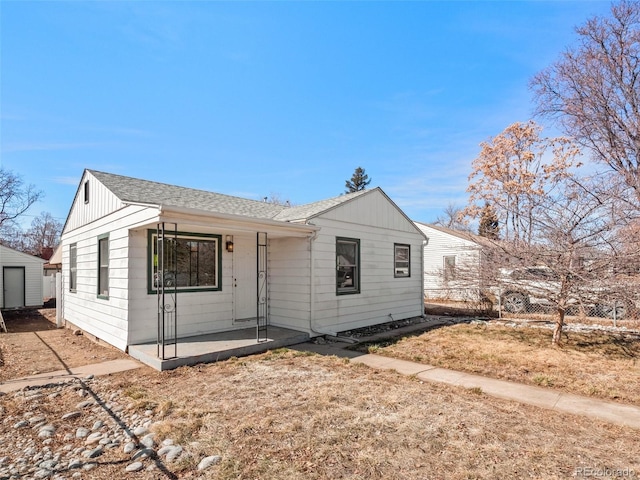 view of front of house featuring an outbuilding, board and batten siding, and roof with shingles