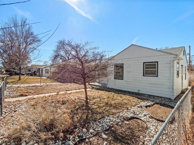 view of side of home featuring fence