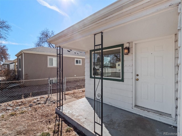 property entrance with fence and stucco siding