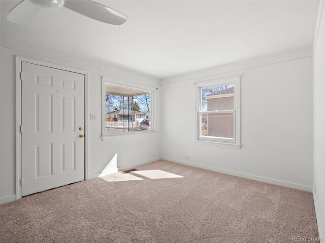 empty room with ceiling fan, carpet flooring, and baseboards