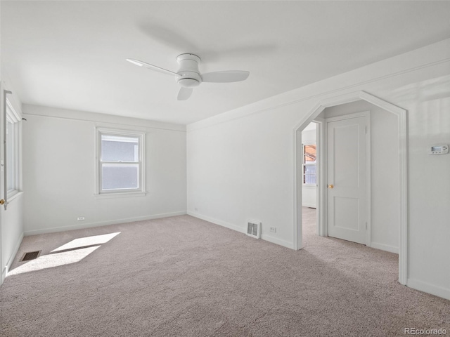 empty room featuring carpet, visible vents, and baseboards